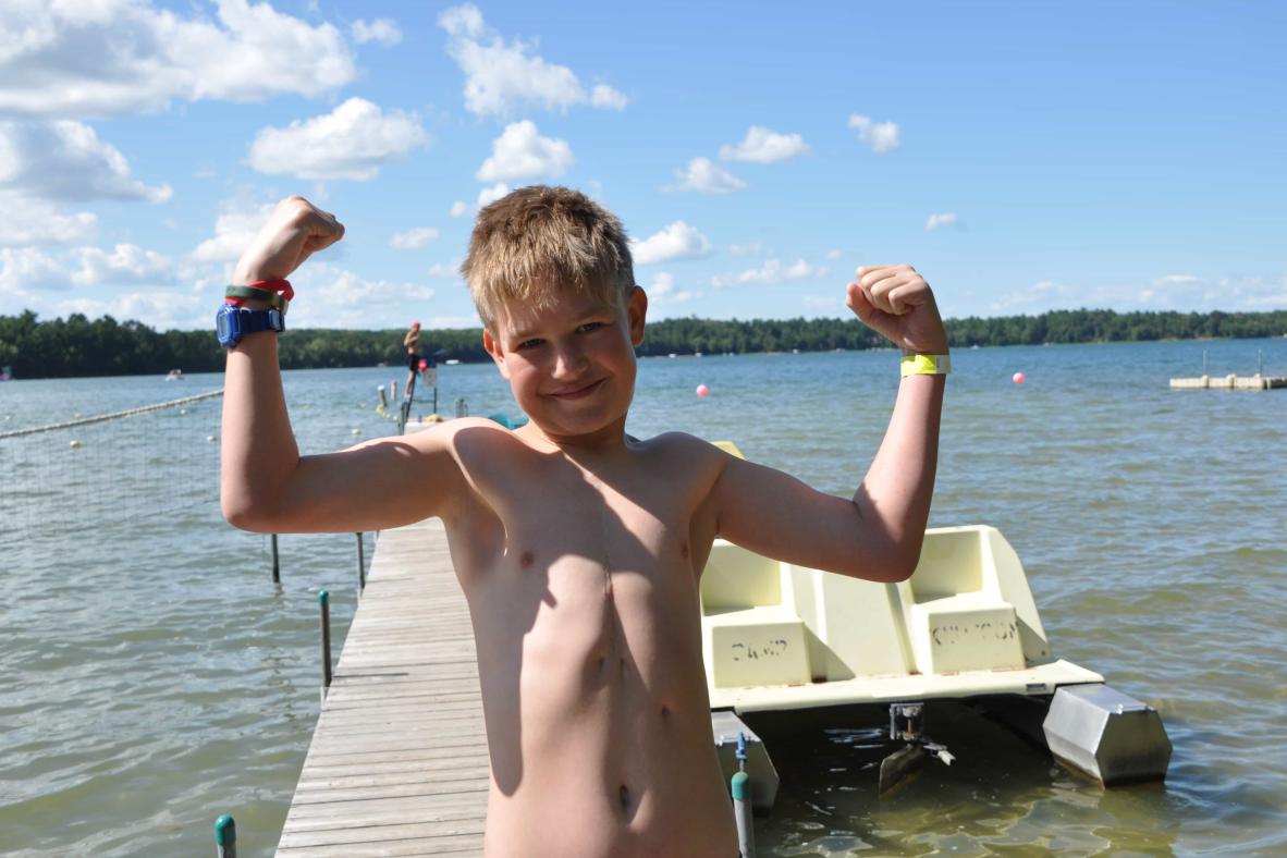 Camper showing his muscles on the dock.