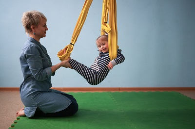 woman working with a child in a sling