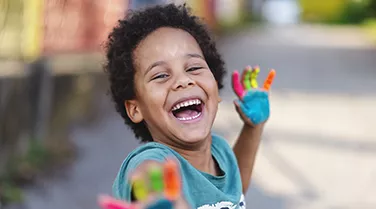 Smiling child with painted hands