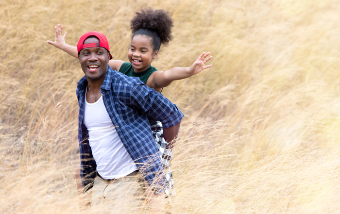 Financial Counseling photo father and daughter running in a prairie field 