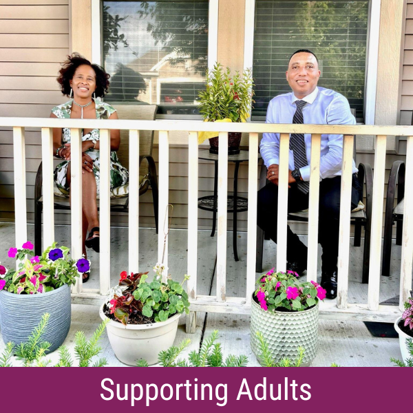 A woman and a man sitting on a porch smiling